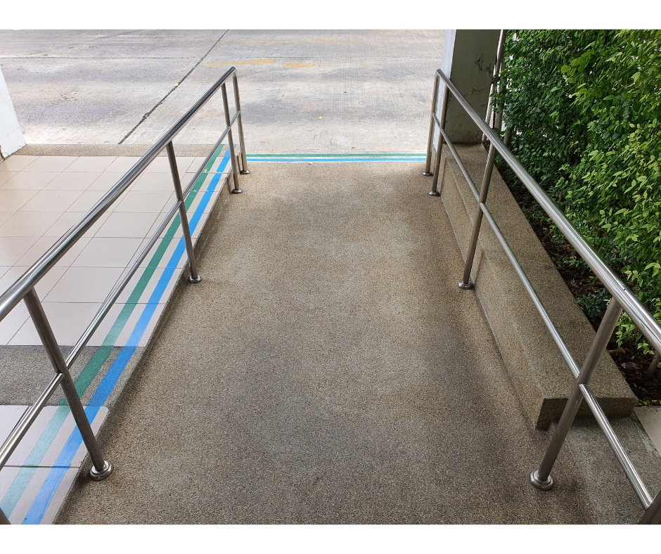 Concrete ramp with metal handrails on a sidewalk